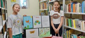 Na zdjęciu widać dziewczynki przy pracach plastycznych z owadami