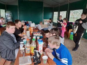 grupa uczniów spożywa posiłek