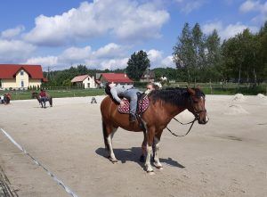 uczeń leżący na koniu