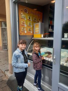 Dziewczynki stoją przy ladzie i składają zamówienie