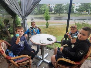 chłopcy siedzą przy stoliku w lodziarni