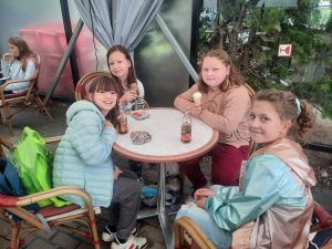 dziewczynki siedzą przy stoliku w lodziarni