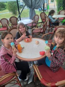 dziewczynki siedzą przy stoliku w lodziarni