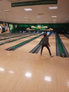 na zdjęciu widać tory kręgielni i uczennicę rzucającą kulą