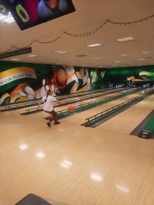 na zdjęciu widać tory kręgielni i uczennicę rzucającą kulą