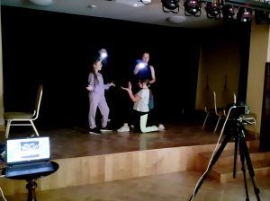 Trzy dziewczyny, uczestniczki warsztatów fotograficznych przygotowują obraz pt. Oświadczyny.