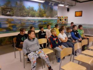 grupa uczniów siedzących na krzesłach