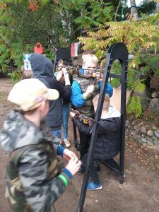 grupa uczniów przy urządzeniu z metalu