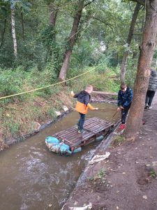 uczniowie na tratwie dobijają do brzegu