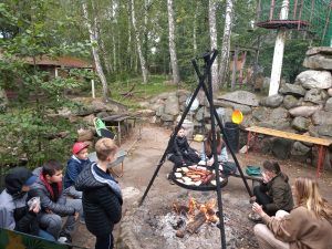 grupa uczniów odpoczywa przy ognisku