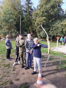 grupa uczniów w kolejce do strzelania z łuku