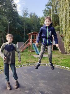 dwaj chłopcy skaczący na trampolinie