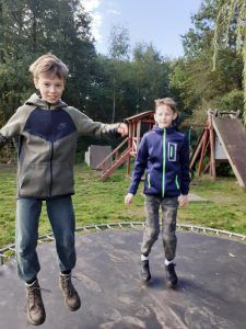dwaj chłopcy skaczący na trampolinie