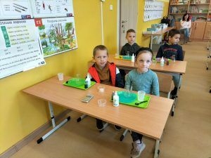 Uczniowie siedzą w ławkach podczas zajęć z Krainą Eksperymentów
