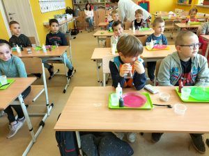 Uczniowie siedzą w ławkach podczas zajęć z Krainą Eksperymentów