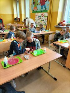 Uczniowie siedzą w ławkach podczas zajęć z Krainą Eksperymentów