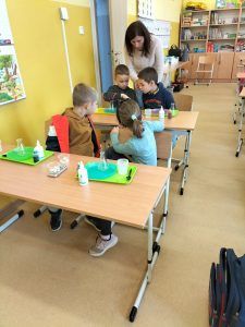 Uczniowie siedzą w ławkach podczas zajęć z Krainą Eksperymentów