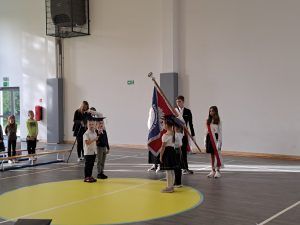 pierwszoklasiści stoją przy sztandarze szkoły 