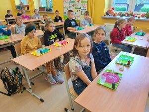 Uczniowie siedzą w ławkach podczas zajęć z Krainą Eksperymentów