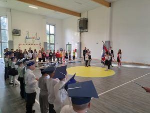 pierwszoklasiści stoją przy sztandarze szkoły 