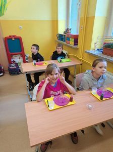 Uczniowie siedzą w ławkach podczas zajęć z Krainą Eksperymentów