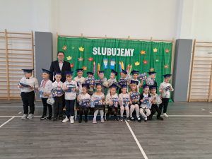 zdjęcie grupowe pierwszoklasistów z dyrektorem i wychowawcą