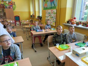 Uczniowie siedzą w ławkach podczas zajęć z Krainą Eksperymentów