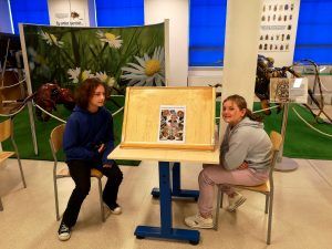 dwie uczennice przy tablicy z plakatem