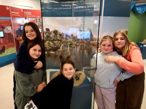 grupa uczennic przy szklanej wystawie