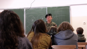 żołnierz w mundurze przed grupą uczniów
