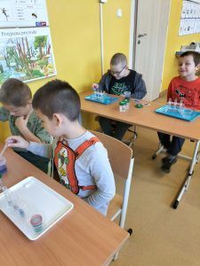 uczniowie wykonują doświadczenie
