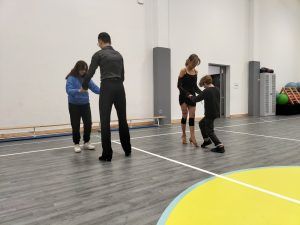 na zdjęciu para tancerzy uczy podstawowych kroków parę uczniów