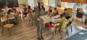 uczennica rozdaje pączki w oddziale przedszkolnym