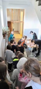 uczniowie w kolejce do wymiany baterii i nakrętek na pączki