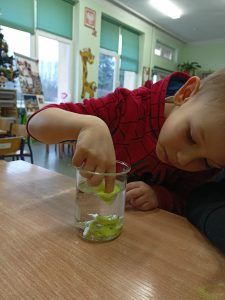 Dziewczynka poznaje właściwości suchego piasku.