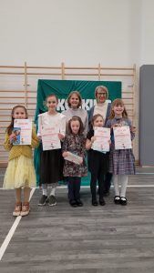 na zdjęciu laureaci konkursu z jurorką i bibliotekarzem