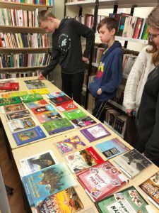 grupa uczniów ogląda wystawę lektur