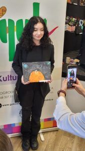 na zdjęciu uczennica ze swoją pracą plastyczną