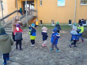 grupa przedszkolaków poszukuje ukrytych jajek przed szkołą