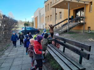 grupa przedszkolaków poszukuje ukrytych jajek przed szkołą