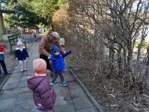 grupa przedszkolaków poszukuje ukrytych jajek przed szkołą