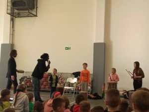 uczniowie grający na bębnach