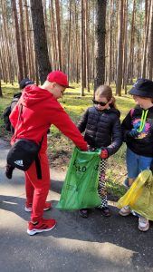 uczniowie segregujący śmieci zebrane w lesie