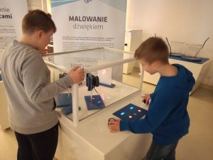 Uczniowie wykonujący doświadczenia z dźwięku i słuchu