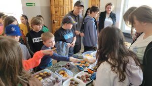 uczniowie przy stoisku z ciastem