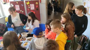 uczniowie przy stoisku z ciastem