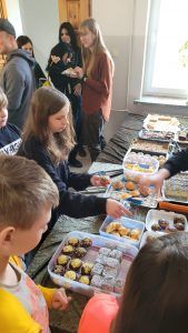 uczniowie przy stoisku z ciastem