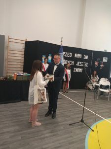 uczennica odbiera nagrodę od dyrektora szkoły