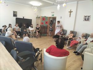 uczennice czytają wiersz seniorom