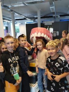 grupa uczniów przy makiecie zębów